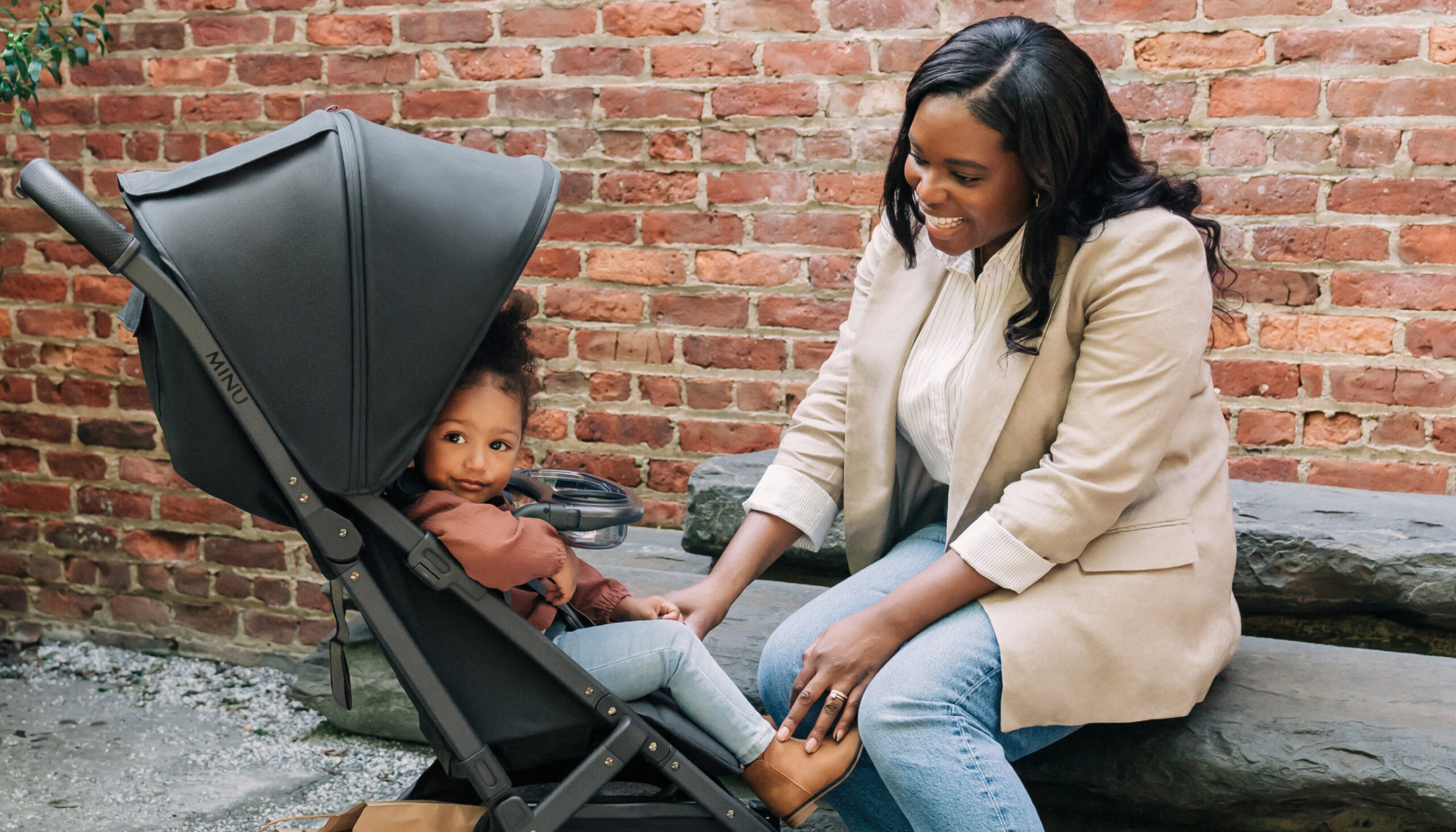 Parent smiling at child in Minu with Snack Tray attached