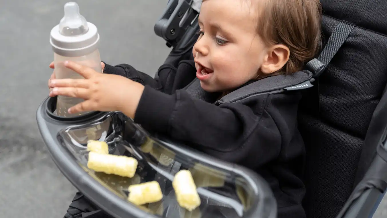 Child in Ridge grabbing bottle from Snack Tray