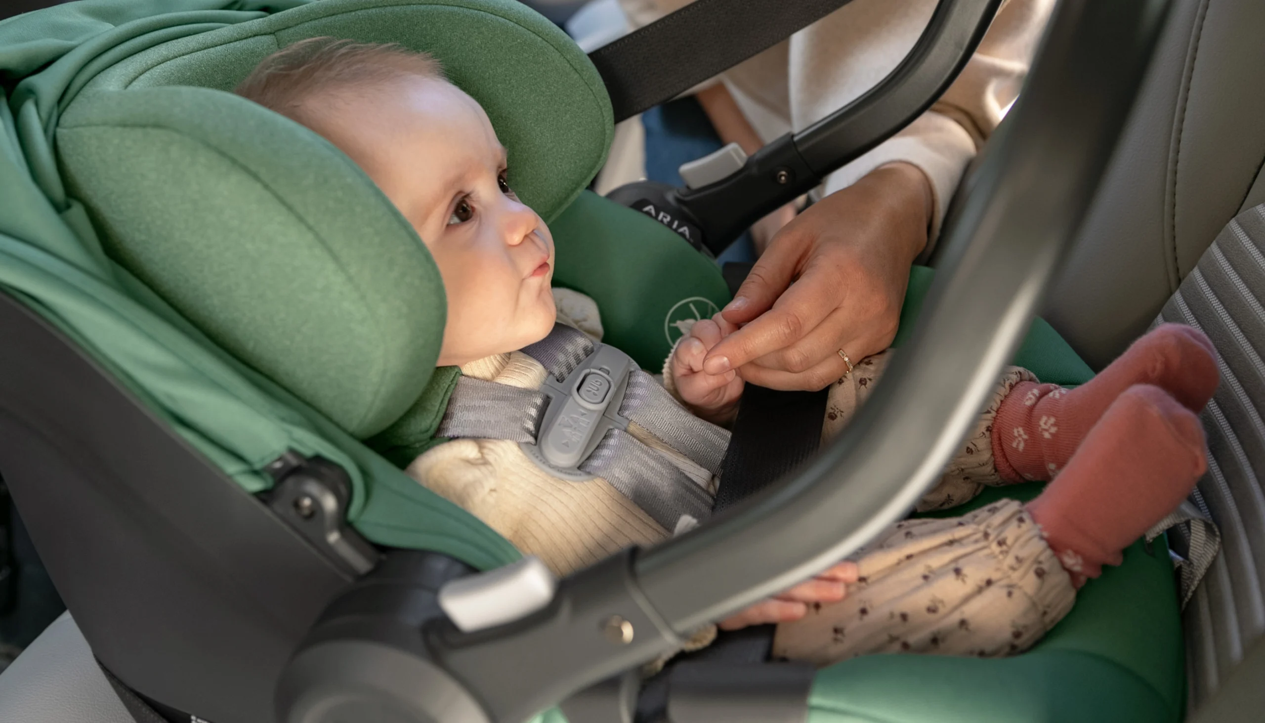 Baby securely buckled into Aria Infant Car seat in Gwen fashion