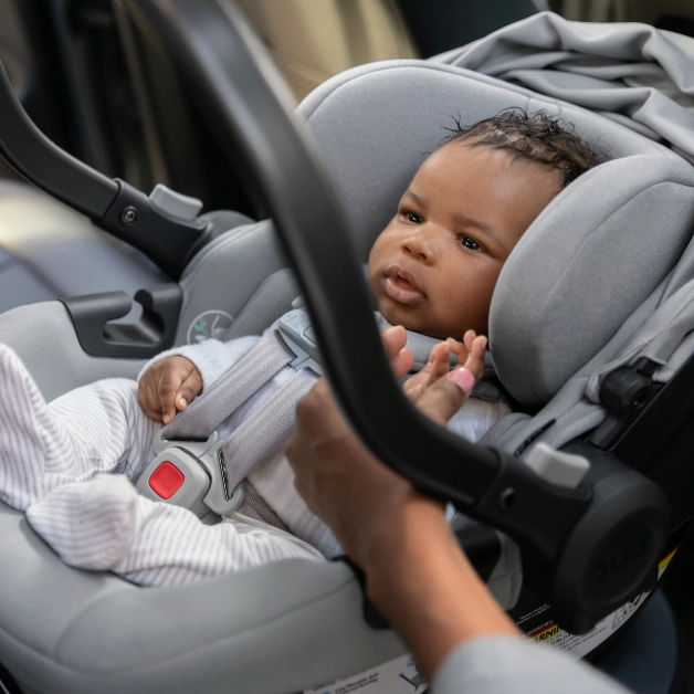 An infant child snugly fit in the Aria car seat with its two-piece robust infant insert to ensure safe and proper body positioning