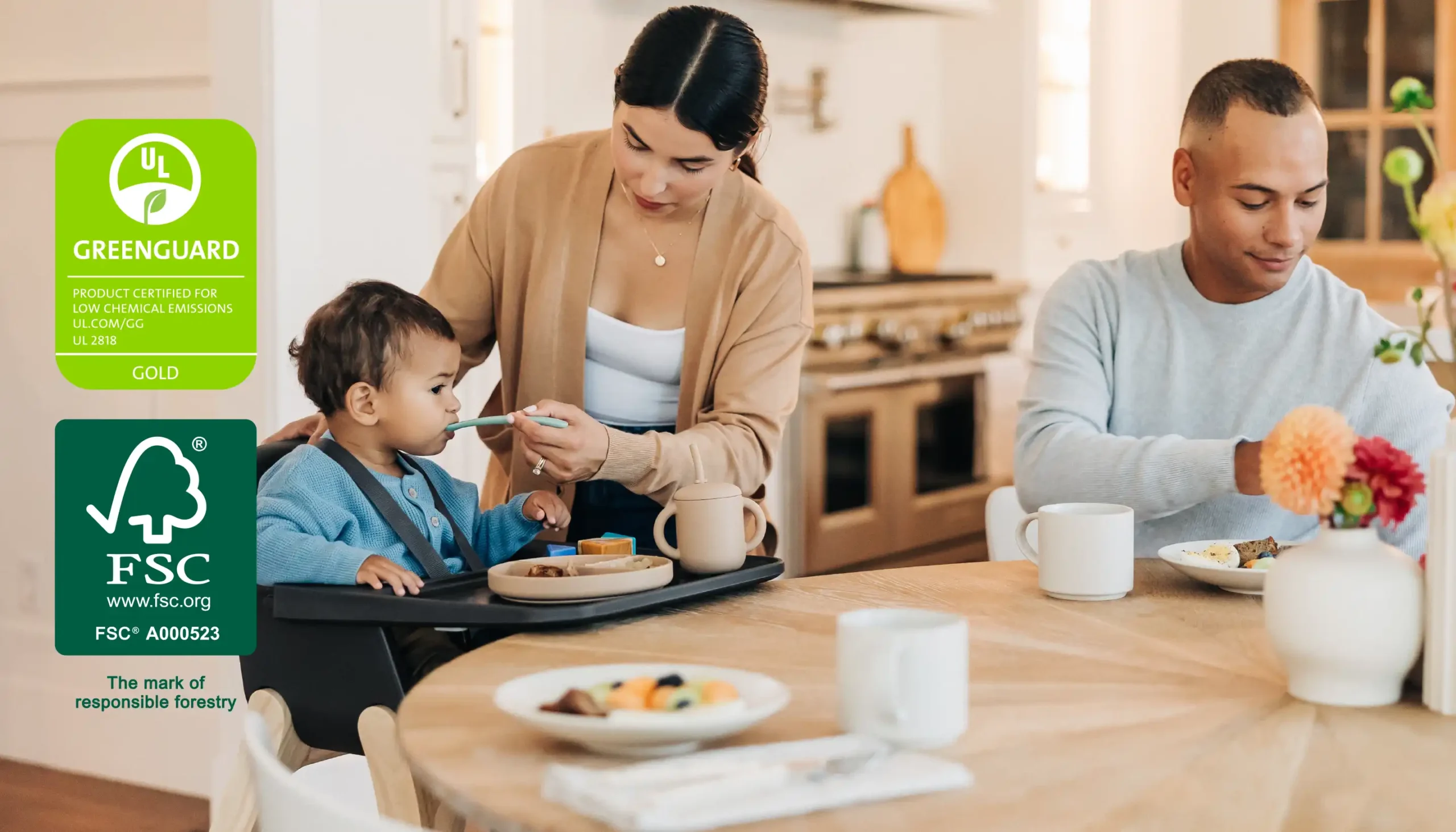 A kind woman feeds her child in the Ciro High Chair, which is GREENGUARD Gold, JPMA, and FSC Certified, making it a safe, sustainable space for baby to sit and eat