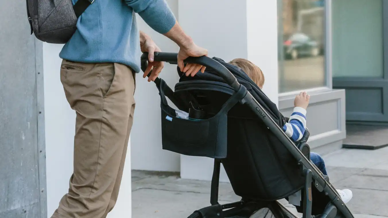 Parent strolling with Carry-All Parent Organizer attached to stroller