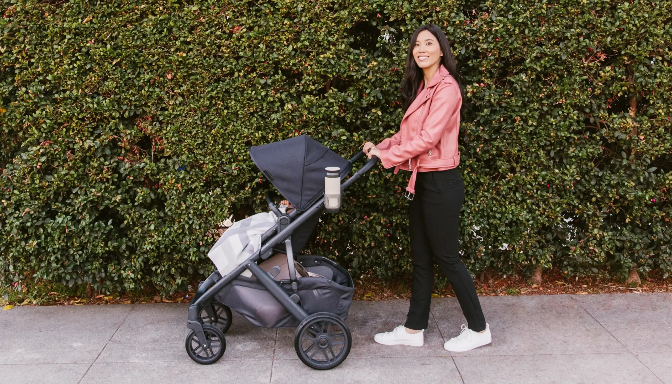 Mom strolling with child in Vista with Cup Holder attached