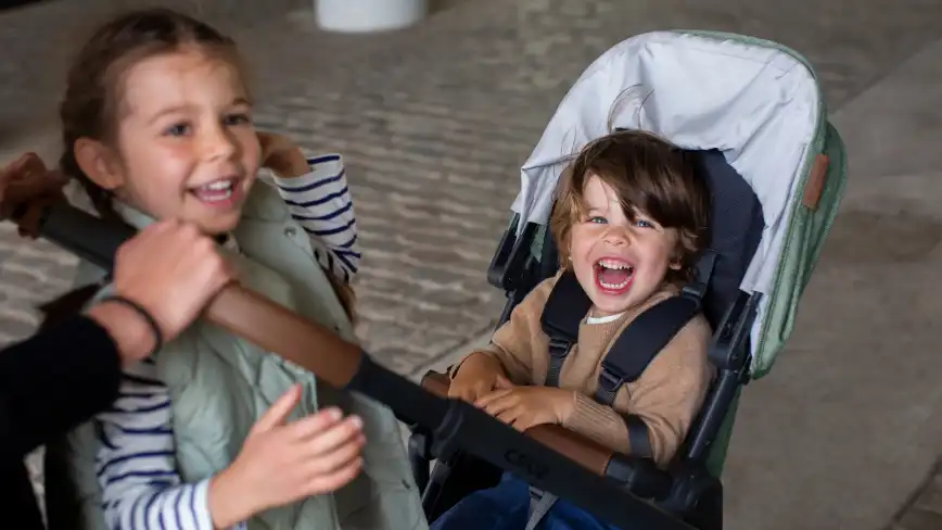 Child on PiggyBack and parent facing child in Cruz V2 Stroller