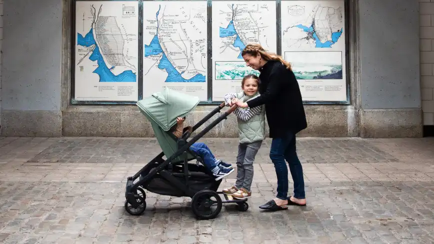 Parent pushing child on PiggyBack and parent facing child in Cruz V2 Stroller