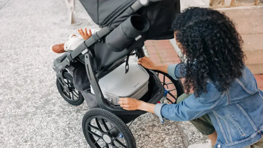 Parent zips up Bevvy™ cooler inside Ridge Stroller Basket