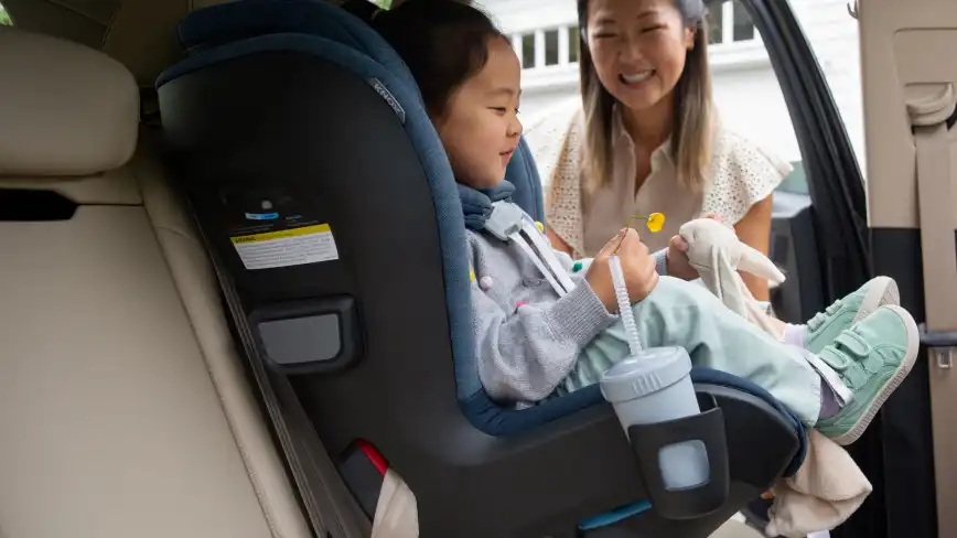 Child sitting in Knox with bottle in Cup Holder