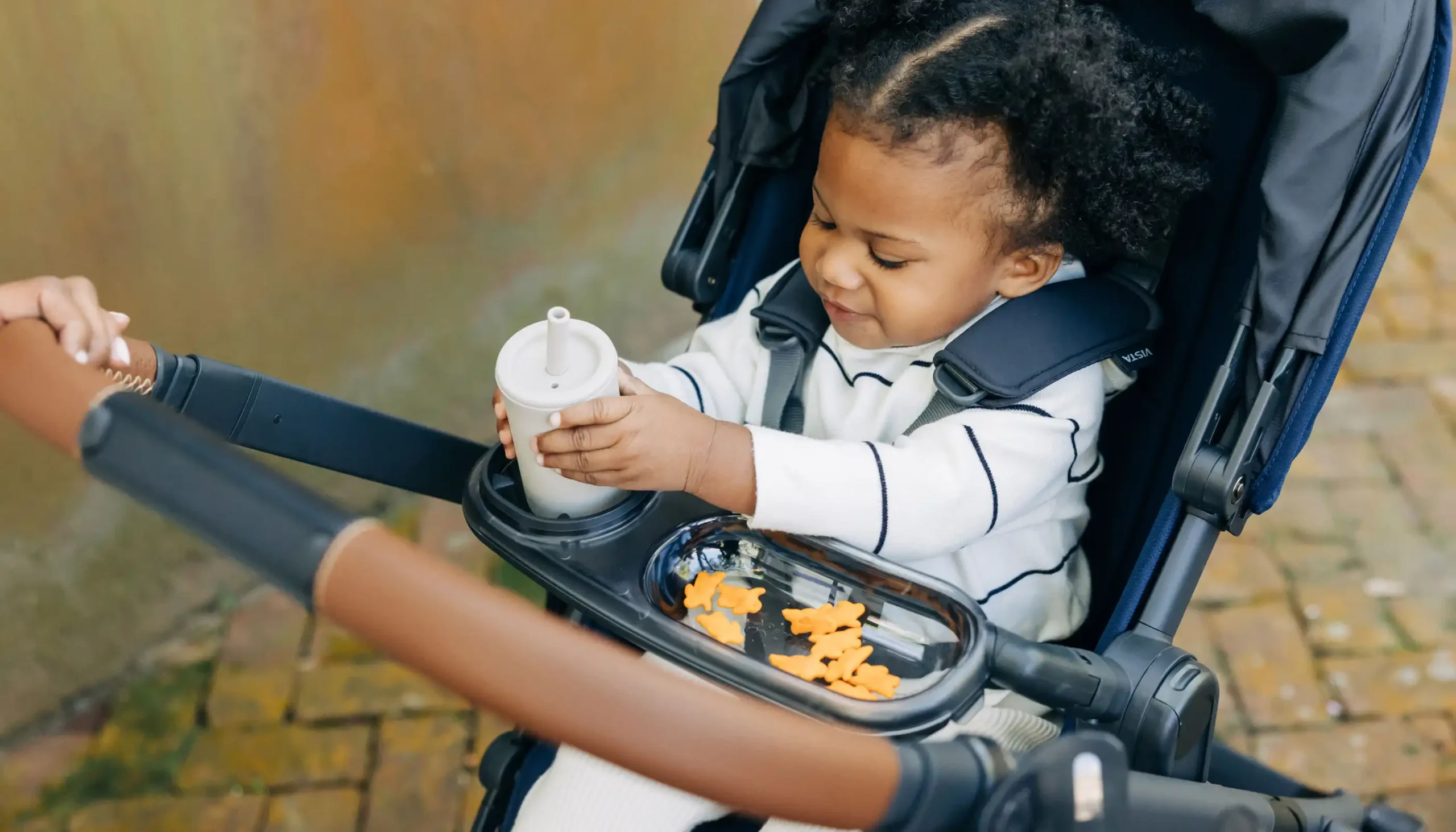 Parent facing child eating snacks from Snack Tray