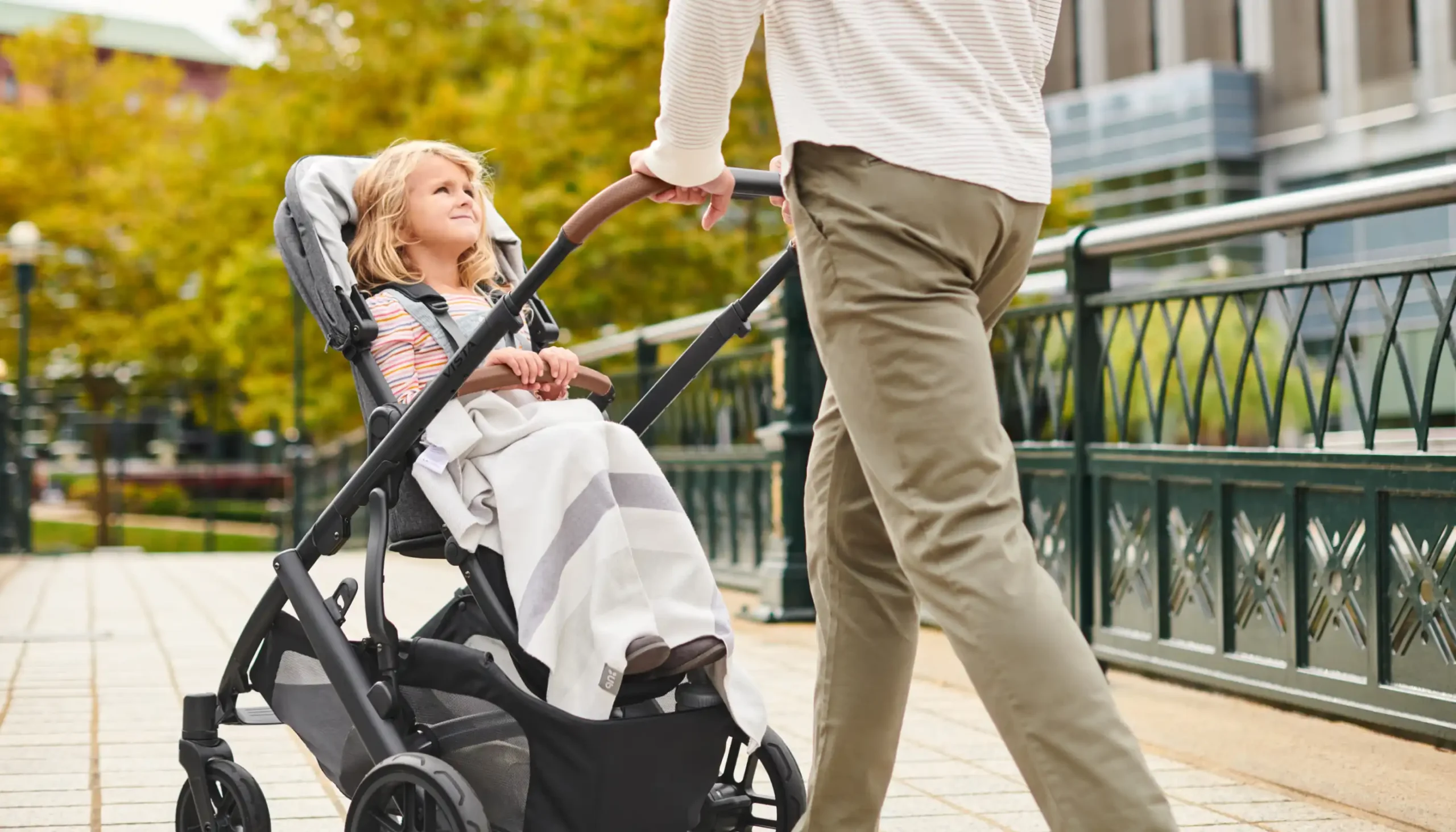 Child in stroller bundled in Knit Blanket being pushed by parent