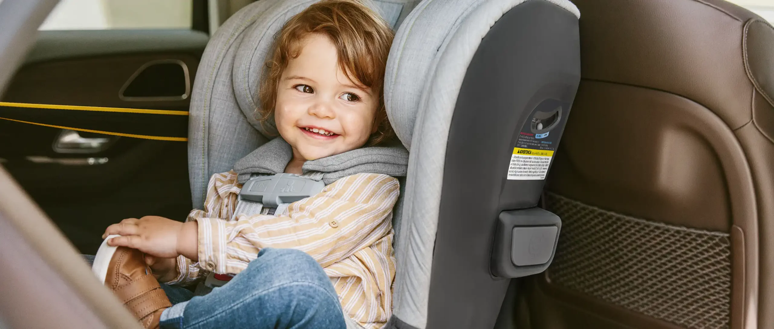 Child smiles as he is securley strapped into the Knox convertible car seat