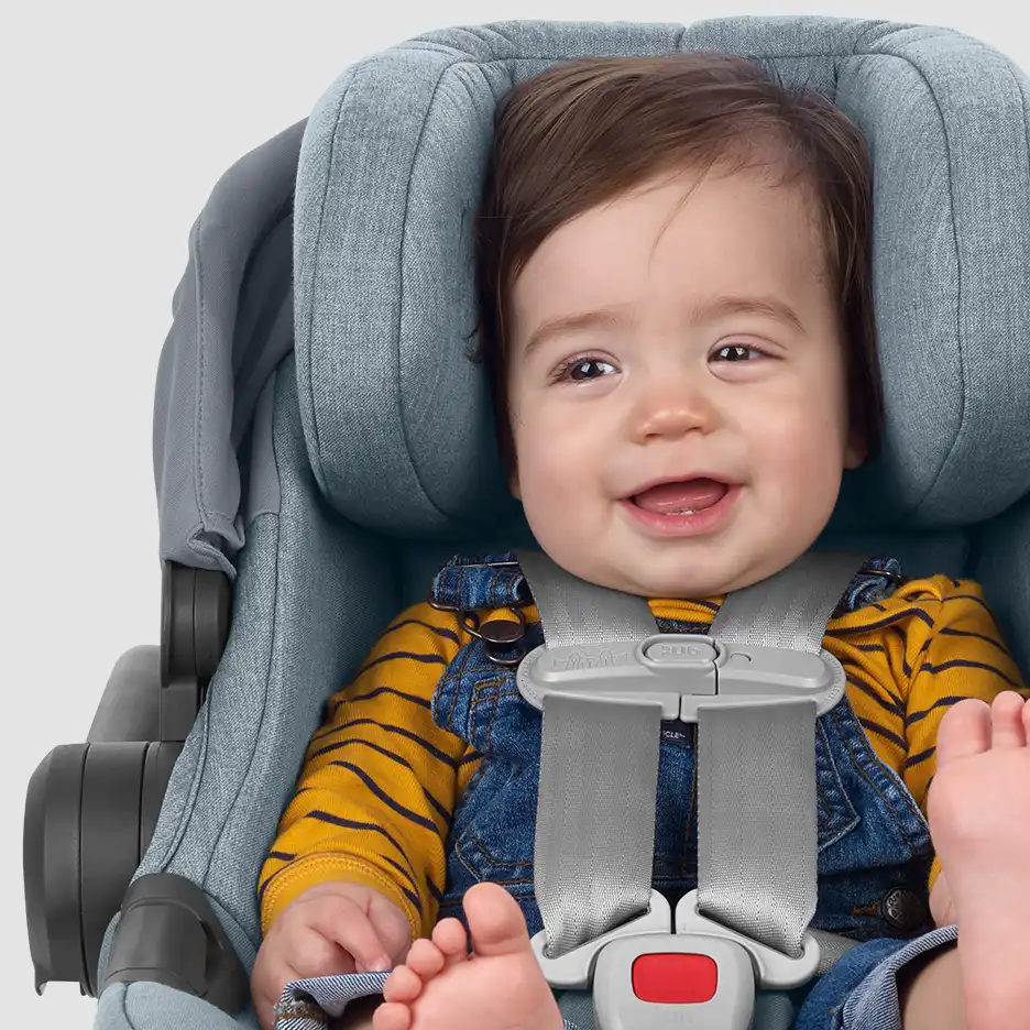 Infant smiling as they are properly and safely fit in car seat with chest clip at armpit level