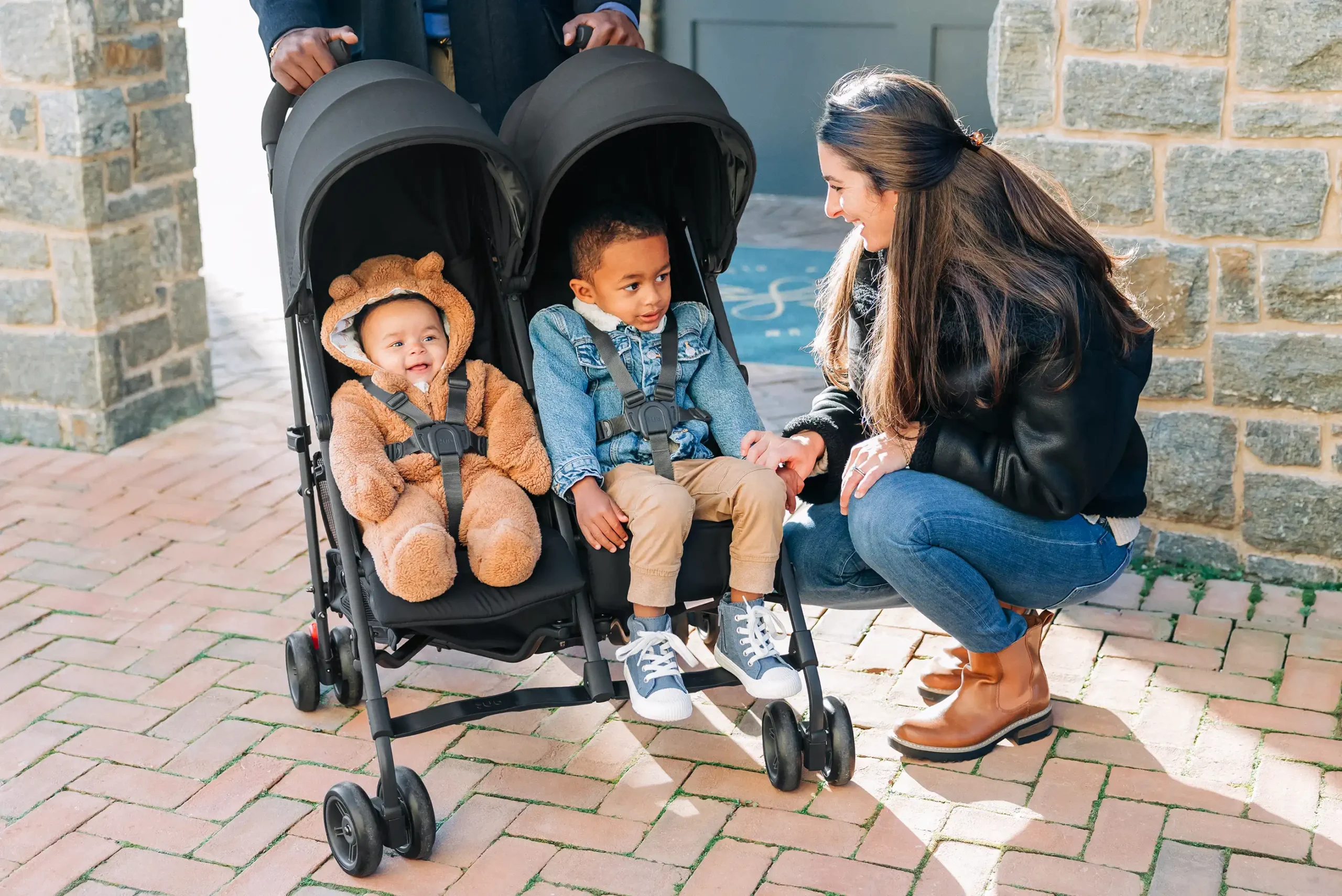 Two happy children of different ages both buckled in comfortably to the G-Link V2 stroller, as the stroller is suitable from 3 months to 55 lbs in each seat!