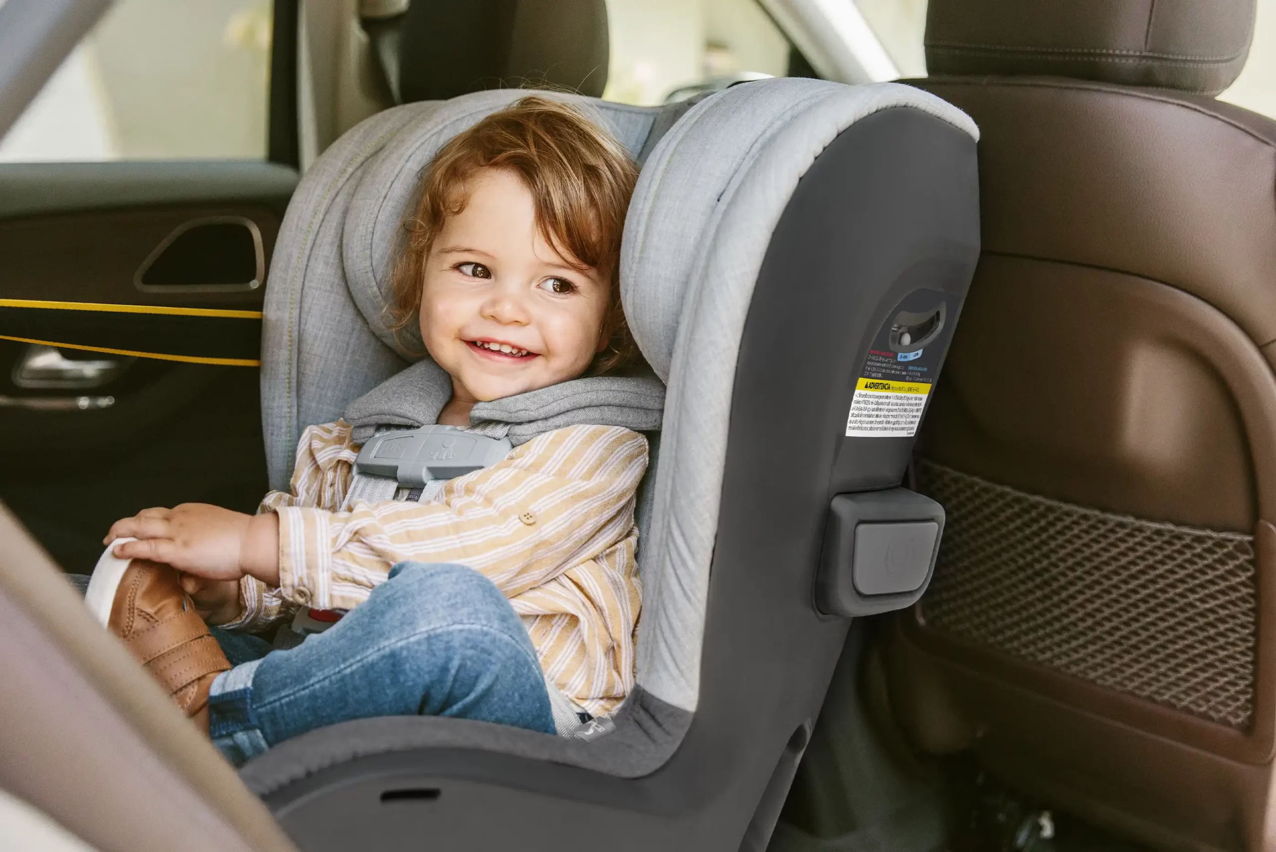 A child smiles in the Knox Convertible Car Seat, fully protected with Knox's side impact pods for additional impact absorption and EPP foam between the inner and outer shell ensures forces are absorbed into the seat